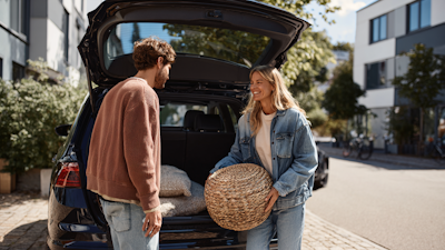 Man giving a woman a foot stool she has bought from him